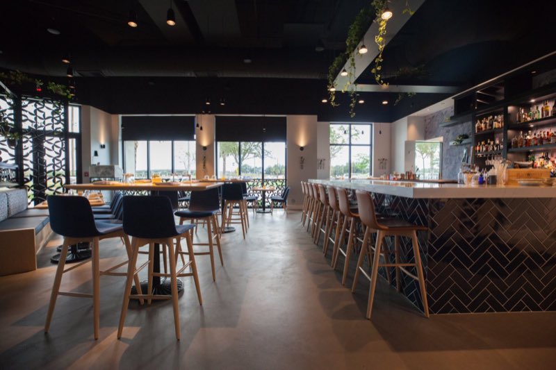 The bar, with its herringbone tile front and the wine wall behind