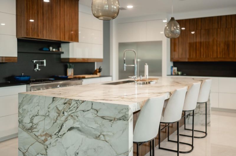 Kitchen with a marble island and walnut cabinetry