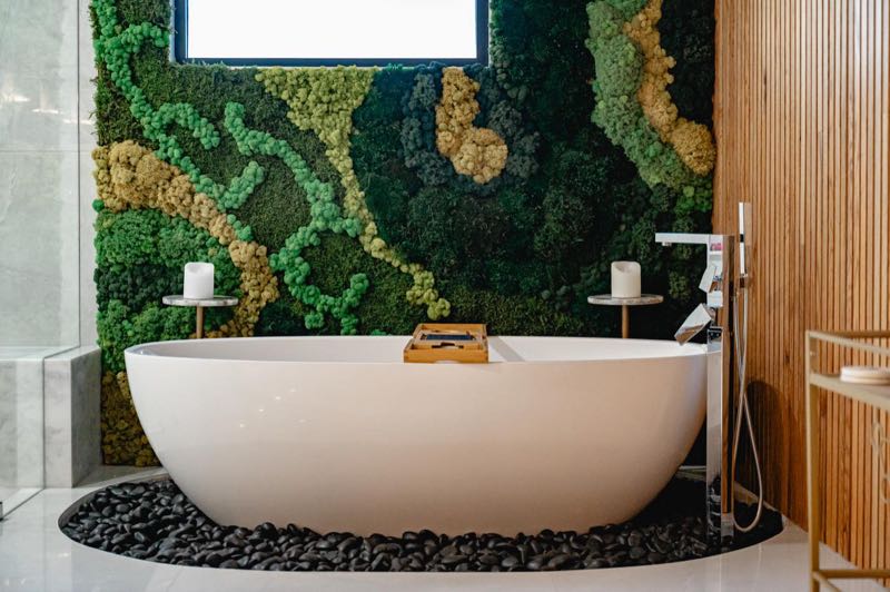 Freestanding tub against a living moss wall