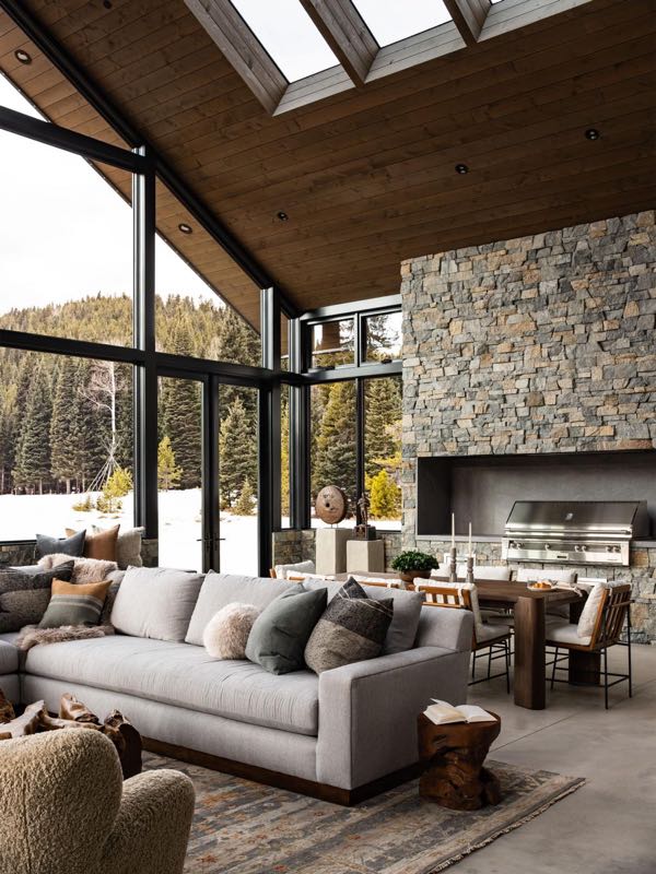 Four-seasons room with stone fireplace and mountain view