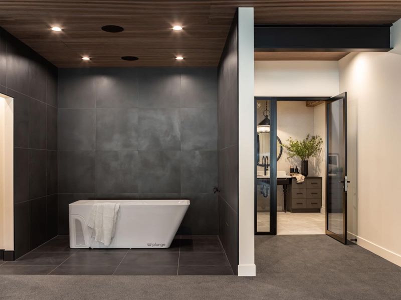 Freestanding tub in the dark-tiled primary bath